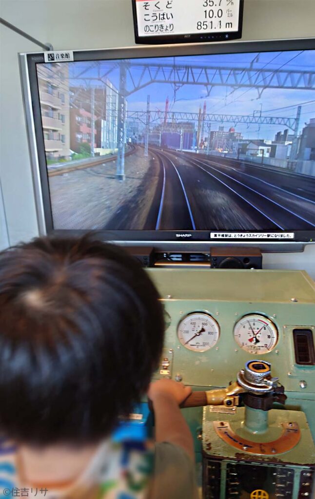 電車の運転シミュレーションを楽しむ子どもの写真
